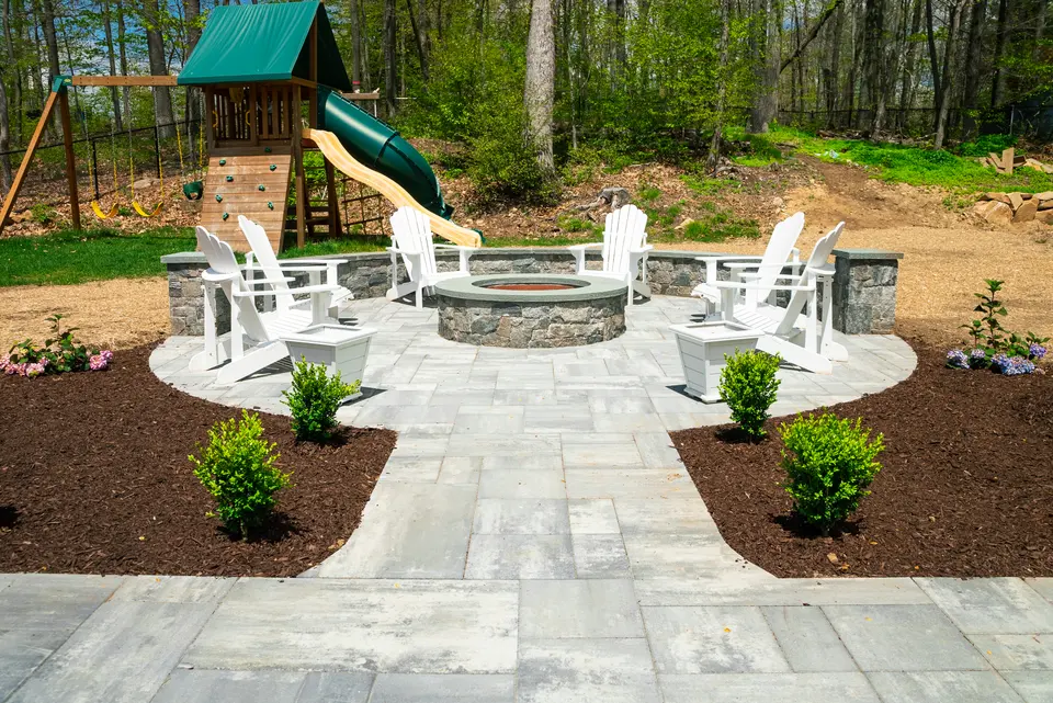 Fire pit ringed by adirondacks inside a stone seat wall — Exterior Services LLC, Newtown, CT
